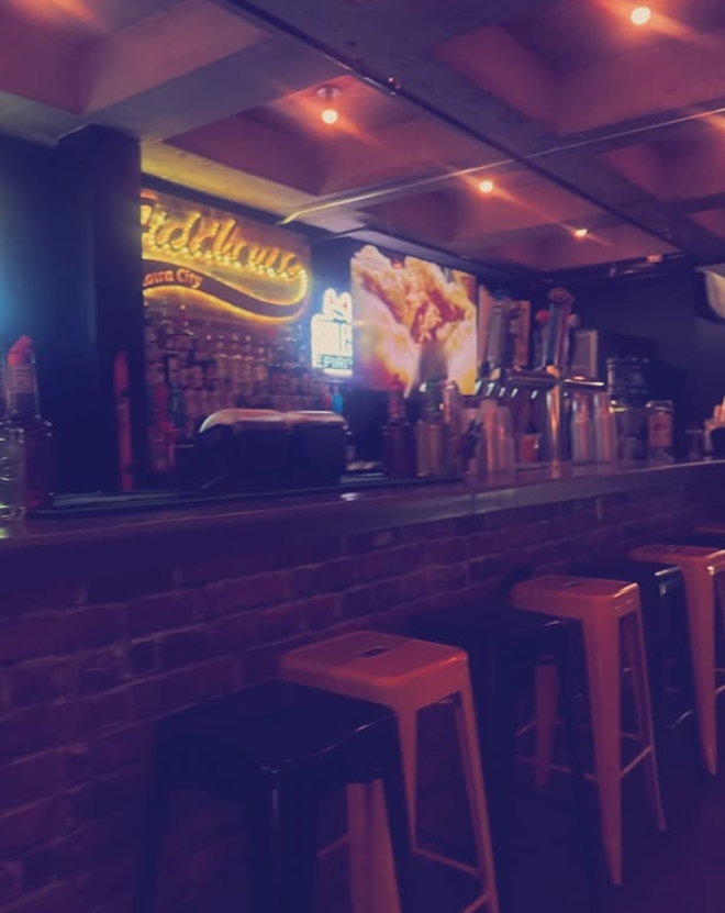 Fieldhouse bar seating and taps glowing at night
