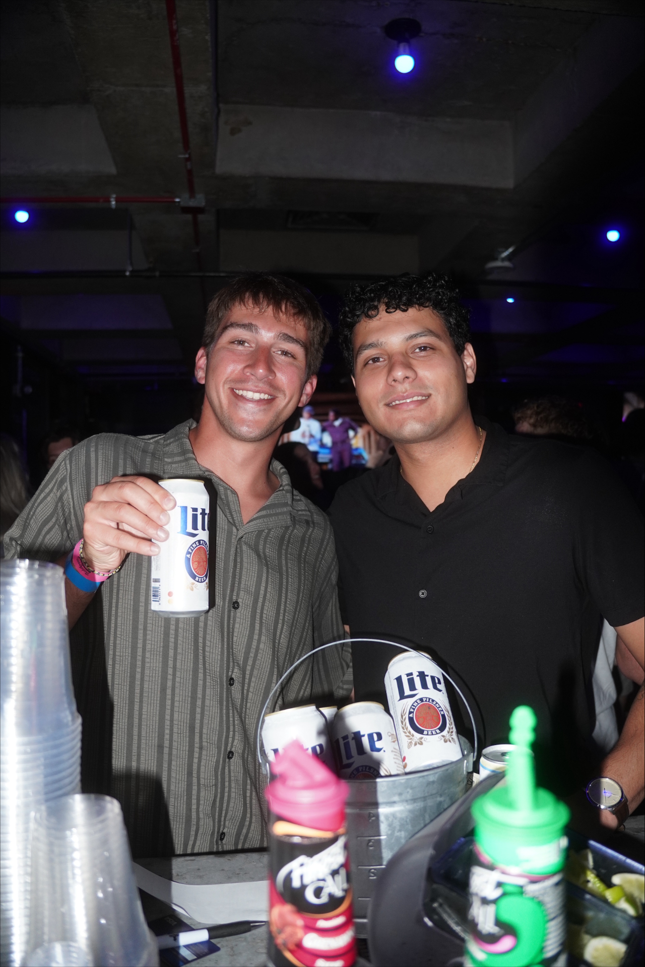 Guests posing with drinks inside Fieldhouse
